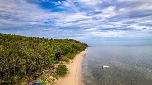 The photo captures a breathtaking view of a serene beach with crystal-clear waters.