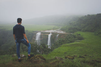 Man standing on field against mountain