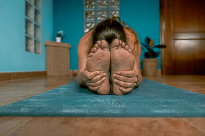 Woman exercising while sitting on mat at home