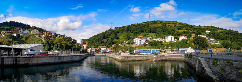 Panoramic view of river amidst buildings against sky