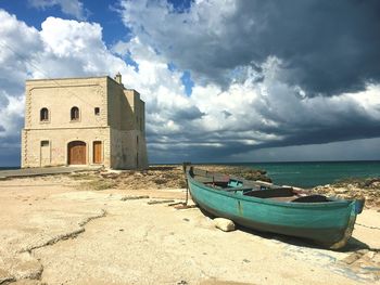 Boat moored on beach against sky