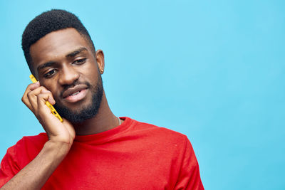 Portrait of young man against clear blue sky