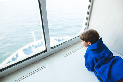 Rear view of boy sitting in boat