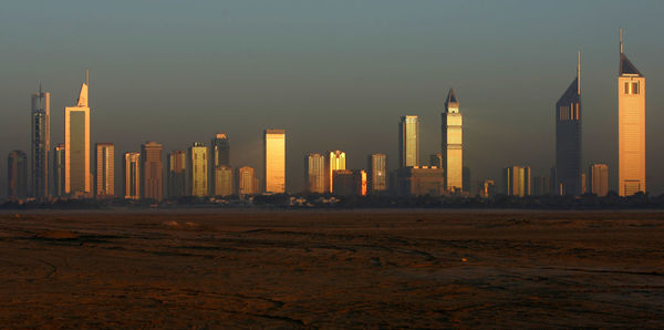 Emirates towers and skyscrapers against sky during sunrise