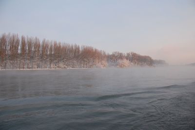 Scenic view of lake against clear sky during winter