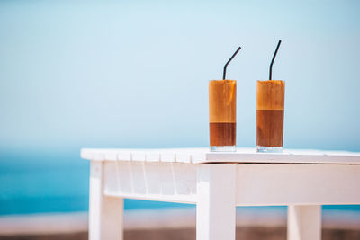 Close-up of drink on table against sea