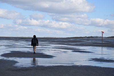 Rear view of person walking at beach