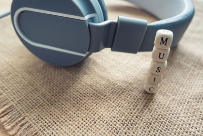 Stack of alphabet blocks and headphones on burlap