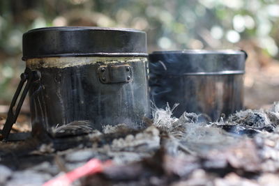 Close-up of containers on bonfire in forest