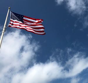 Low angle view of flag against blue sky