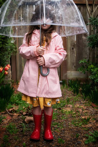 Woman with umbrella standing in rain during rainy season