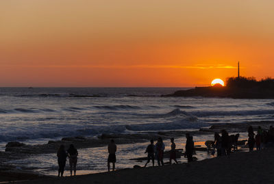 Silhouette of people on beach during sunset