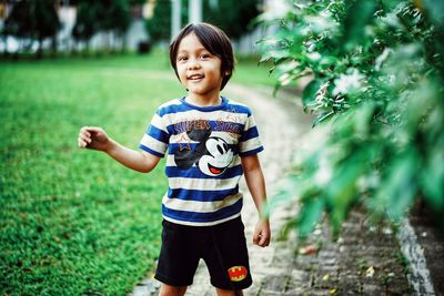 Full length of boy standing against plants