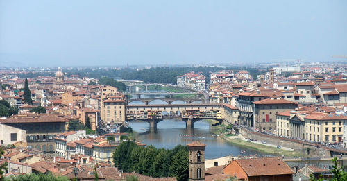 High angle view of illuminated city by river against sky