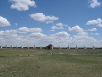 Built structure on field against cloudy sky