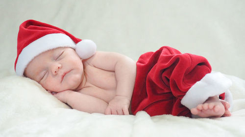 Close-up of baby boy lying on bed