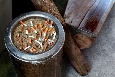 High angle view of cigarette butts in garbage can