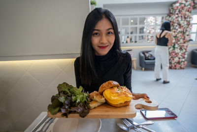 Portrait of woman holding food at home