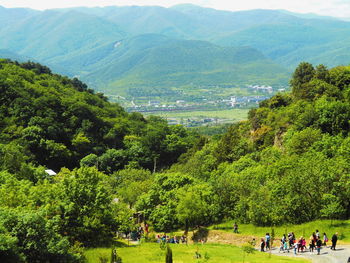 People on green landscape against mountains