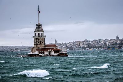 Maiden tower on sea against sky
