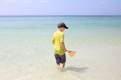 Full length rear view of man standing on beach