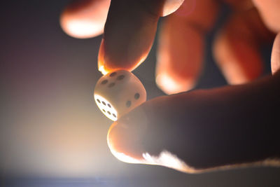 Close-up of hand holding a dice at night