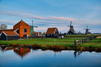 Houses by lake against sky