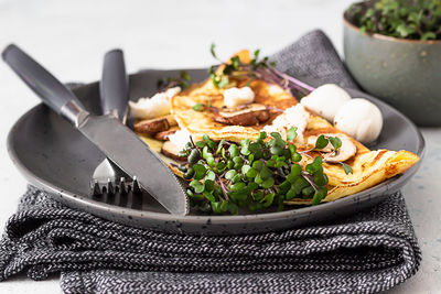 Classic egg omelette or omelet served with mushrooms, mozzarella and microgreens. breakfast. 