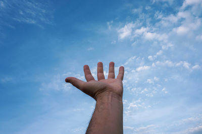 Low angle view of hand against sky