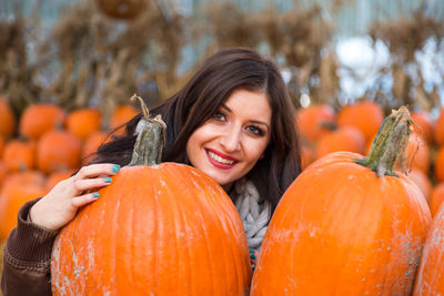 Portrait of a smiling young woman with pumpkins