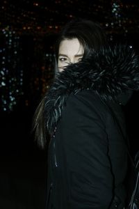 Portrait of woman standing at night during winter