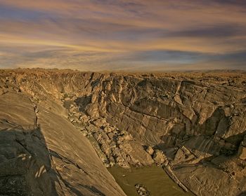 Scenic view of dramatic landscape against sky during sunset