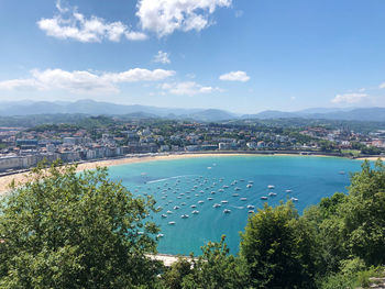 High angle view of city by sea against sky