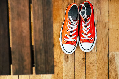 High angle view of orange shoes on hardwood floor