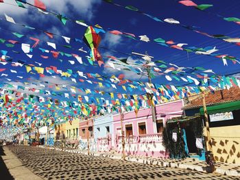 Multi colored umbrellas hanging against sky