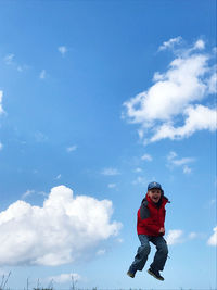 Low angle view of boy against sky