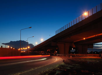 Light trails on road against sky at night