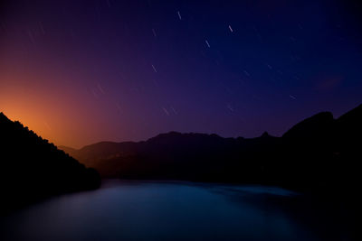 Scenic view of silhouette mountains against sky at night