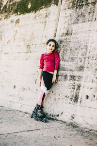 Portrait of woman standing against wall