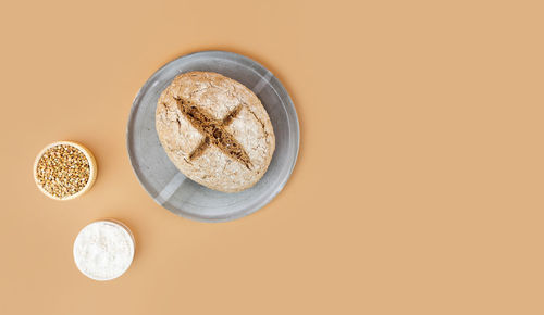 Minimalistic beige background with green buckwheat bread. gray homemade ceramic plate. copy spase