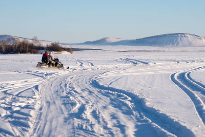 People skiing on snow covered landscape