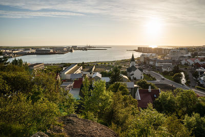 High angle view of townscape by sea against sky