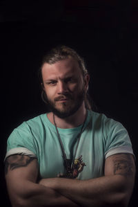 Portrait of young man against black background