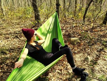 Woman relaxing on leaves in forest