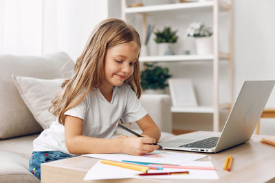Young woman using laptop at table