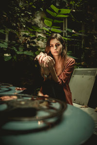 Portrait of young woman sitting at table during night