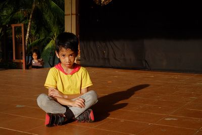 Full length of boy sitting on floor