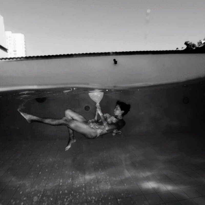 HIGH ANGLE VIEW OF WOMAN SWIMMING IN POOL