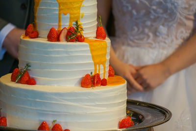 Midsection of woman holding cake