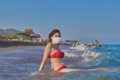 Woman on beach against clear sky